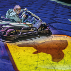 Un joueur BattleVirus dans son kart roule sur une case jaune pour récupérer un bonus missile