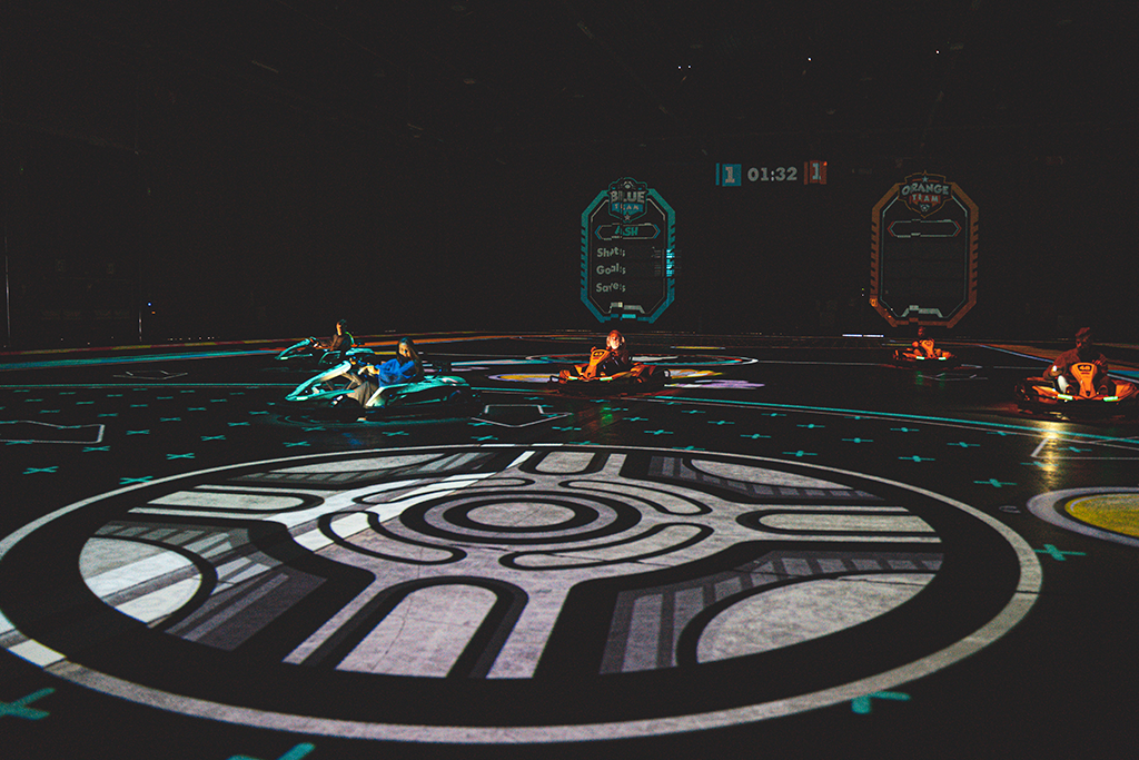 BattleKart players in the background in their karts with BattleFootball ball in the centre